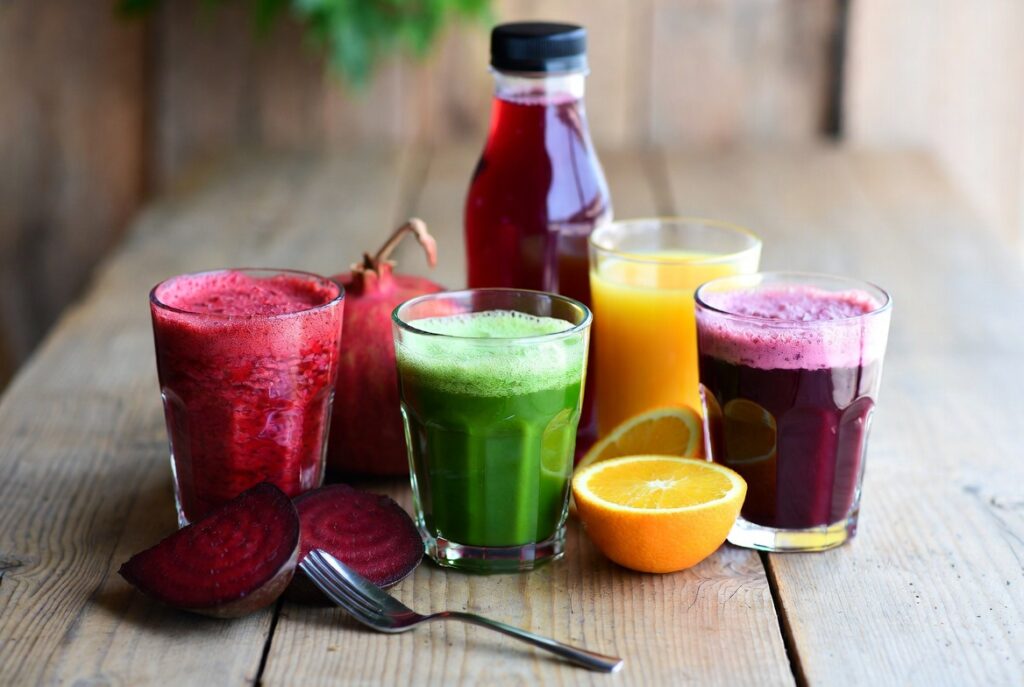 natural drinks for blood circulation including beet juice lemon water and herbal tea on a wooden table